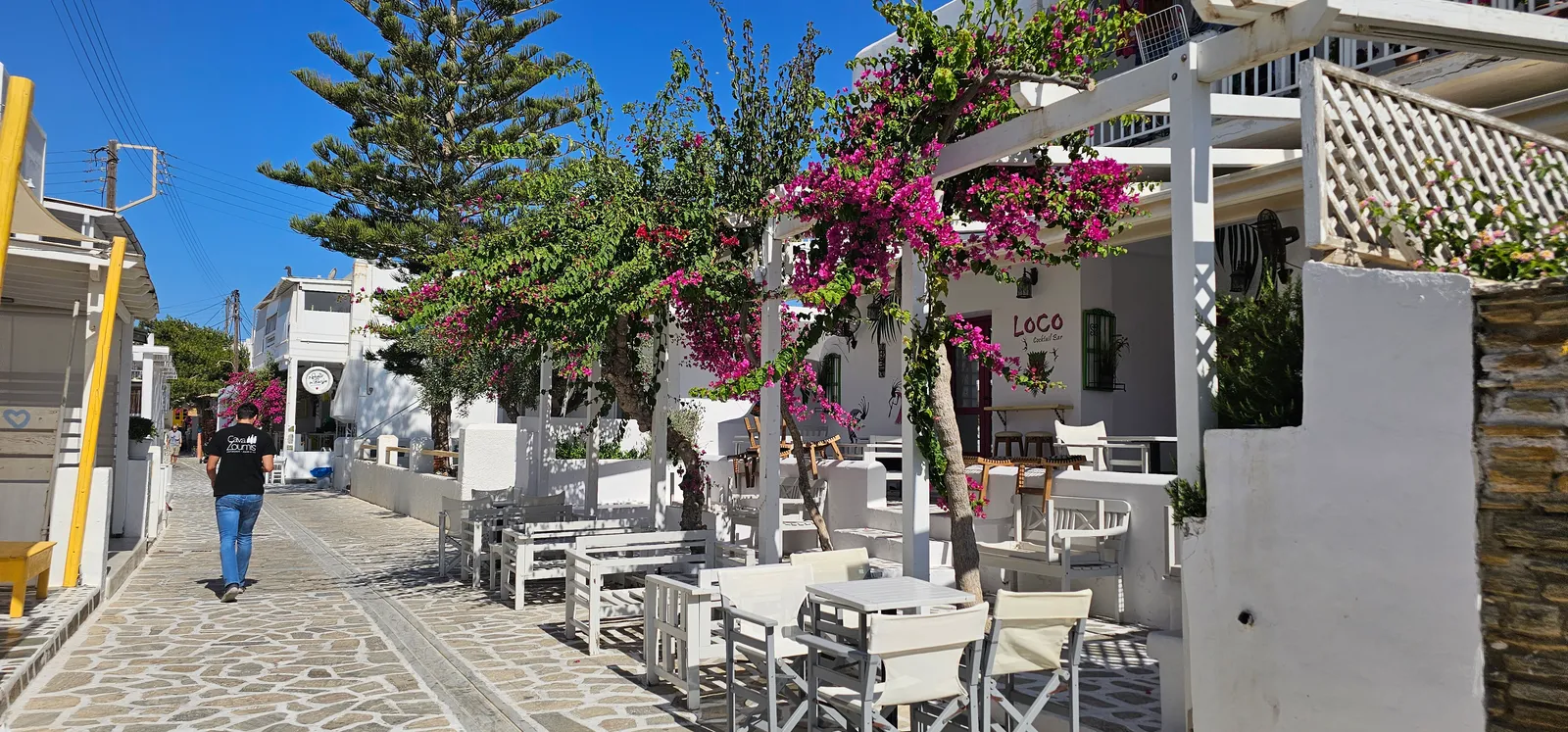 Bougainvillea ja tavernan pöydät Antiparoksen kylässä
